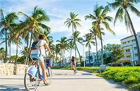 Mujer paseando en biclieta por Miami Beach